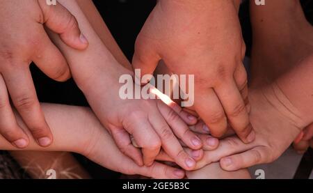 Die Hände der Kinder stapelten sich übereinander Stockfoto