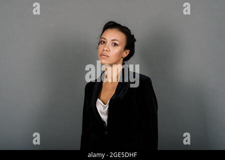 Eine isolierte Aufnahme einer glücklichen schwarzen Geschäftsfrau im Studio, Notebook, Smartphone Stockfoto
