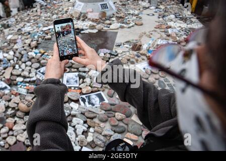 Buenos Aires, Argentinien. August 2021. Eine Frau fotografiert die Steine. Marsch der Steine, eine Hommage an die Opfer von Covid-19 und Ablehnung der Regierung. Der Aufruf zielt darauf ab, jeden der durch das Coronavirus Verstorbenen mit einem Stein zu repräsentieren und vor den Gebäuden der Zentralregierung aufzudecken, um das Management der Pandemie in Buenos Aires, Argentinien, zu widerlegen. Kredit: SOPA Images Limited/Alamy Live Nachrichten Stockfoto