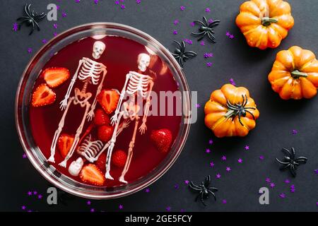 Happy Halloween Party Komposition. Flach liegend, Draufsicht Schale mit blutiger Farbe Getränk, Kürbisse, Spinnen auf schwarzem Hintergrund. Stockfoto