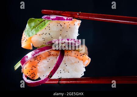 Präsentation einer Portion Sushi mit Beilage auf der Basis roter Zwiebeln Stockfoto