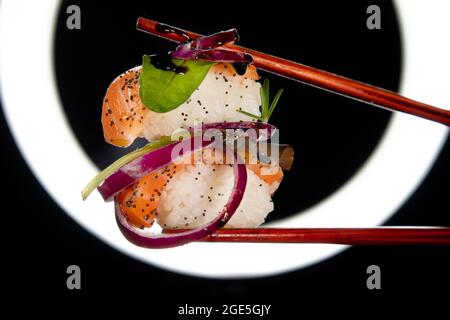 Präsentation einer Portion Sushi mit Beilage auf der Basis roter Zwiebeln Stockfoto