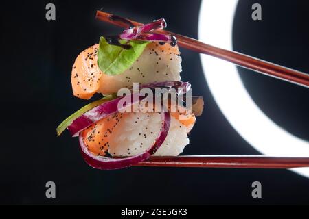 Präsentation einer Portion Sushi mit Beilage auf der Basis roter Zwiebeln Stockfoto