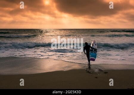 Ein Mitglied des Newquay Surf Lifesaving Club, der während einer Trainingseinheit am Fistral Beach in Newquay in Co mit dem Kracka Rescue Board ins Meer geht Stockfoto