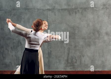 Kleiner Junge und Mädchen tanzen im Ballsaal Wiener Walzer. Stockfoto