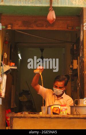 Mann, der Tee für Kunden im Teeladen, Tiruvallur, Tamilnadu, Indien, zubereitet Stockfoto