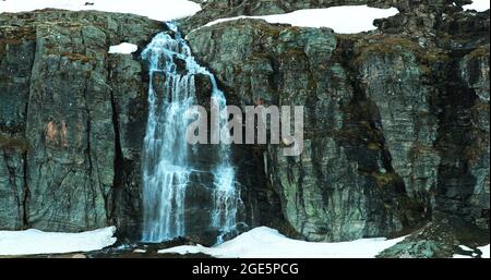 Aurlandsfjellet, Norwegen. Wasserfall Flotvatnet In Spring Snowy Landscape. Straße Aurlandsfjellet. Malerische Route Road Im Sommer Norwegische Landschaft Stockfoto