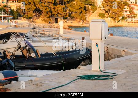 Tanken Yachten mit Wasser auf Segelboot Dock in der Küste. Konzept des Service am Pier. Stockfoto