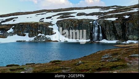 Aurlandsfjellet, Norwegen. Wasserfall Und See Flotvatnet In Spring Snowy Landscape. Malerische Route Road Im Sommer Norwegische Landschaft. Natürliches Norwegisch Stockfoto