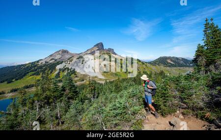 Wanderer mit Blick in die Ferne, vulkanischer Berg Black Tusk, Wanderweg zum Panorama Ridge, Garibaldi Provincial Park, British Columbia, Kanada Stockfoto