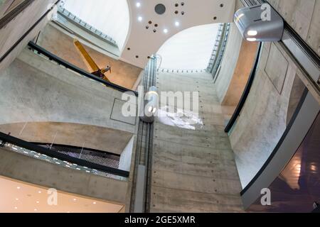 Das hoch aufragende, moderne, brutale Betonatrium mit silbernen Aufzügen. Im Mercedes-Benz Museum in Stuttgart. Stockfoto
