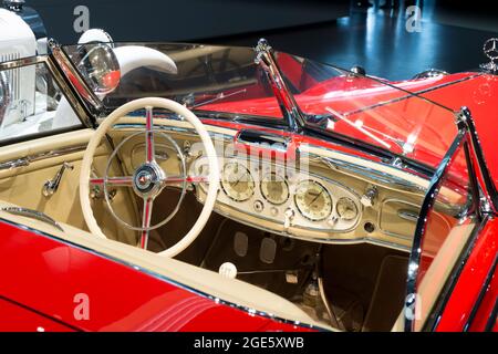 Das cremefarbene, weiße Armaturenbrett, die Instrumentendetails in einem roten Sportwagen. Im Mercedes-Benz Museum in Stuttgart. Stockfoto