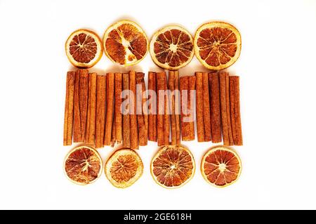 Zimtstangen und getrocknete Grapefruits und Orangen in Scheiben auf weißem Hintergrund. Lebensmittelgeschäft Hintergrund von getrockneten Zitrusscheiben. Stockfoto