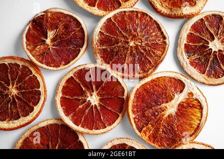 Getrocknete Grapefruits und Orangen in Scheiben auf weißem Hintergrund. Lebensmittelgeschäft Hintergrund von getrockneten Zitrusscheiben. Stockfoto