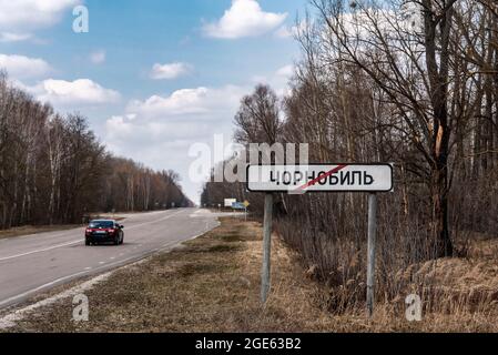 Road to Death Brücke zum Geist verlassene Stadt Pripjat, Wald und dramatischer Wolkenhimmel an sonnigen Tagen im frühen Frühjahr in der Tschernobyl-Ausschlusszone, Ukraine Stockfoto