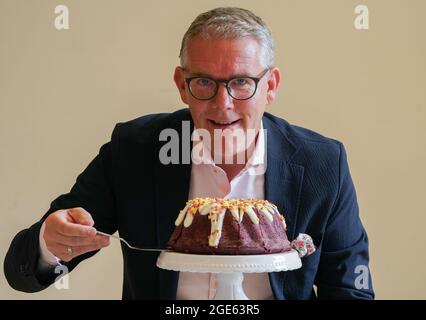 17. August 2021, Sachsen-Anhalt, Halle/Saale: Marco Thiele, Geschäftsführer der Kathi Rainer Thiele GmbH, sitzt an seinem eigenen Geburtstagskuchen. Das hallesche Lebensmittelunternehmen, das fertige Backmischungen und Mehle herstellt, feiert sein 70-jähriges Bestehen. Foto: Peter Endig/dpa-Zentralbild/dpa Stockfoto