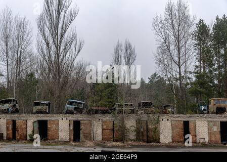 Alte rostige Autos in Tschernobyl Ausschlusszone, Herbstsaison in , Ukraine. Autofriedhof Stockfoto