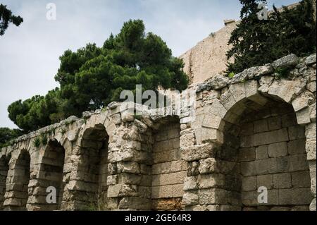 Blick von unten auf die Akropolis von Athen. Alte griechische Siedlung. Wahrzeichen von Athen. Steinmauer mit Bögen. Stockfoto