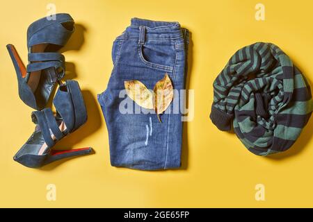 Weibliche Herbstkleidung auf gelbem Hintergrund. Set von Frauen Outfit Kleidung auf gelb Stockfoto