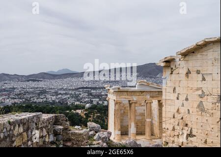 Stadtbild von Athen vom Akropolis-Hügel. Ruins Temple of Athene Nike im Vordergrund. Alte Architektur von Griechenland. Stockfoto