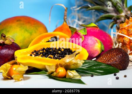 Papaya, Drachenfrucht, Mango, Mangostan, Winterkirsche, Granadilla, Salak und Ananas. Frische Tropische Früchte. Auf blauem Hintergrund. Draufsicht. Obst Stockfoto