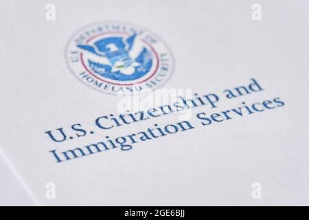 Taschkent, Usbekistan - 13. August 2021: United States Citizenship and Immigration Services. Umschläge mit Brief aus der USCIS auf US-Flagge Stockfoto