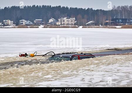 Das Auto brach in das Eis ein und ertrank im See. Arbeit des Rettungsdienstes Stockfoto