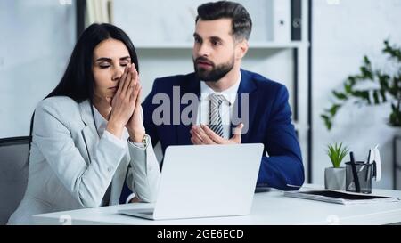 Verärgerte Geschäftsfrau mit geschlossenen Augen fast verschwommen und unzufrieden Geschäftsmann Streit im Büro Stockfoto
