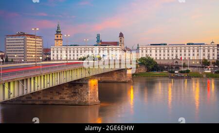 Linz, Österreich. Panorama-Stadtbild des Flussufers Linz, Österreich während der Dämmerung blaue Stunde mit Reflexion der Lichter der Stadt in der Donau. Stockfoto