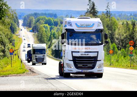 Schwere DAF XF-Lkw, Modell der neuen Generation im Hintergrund, auf der Straße zur Power Truck Show 2021. Ikaalinen, Finnland. 12. August 2021. Stockfoto