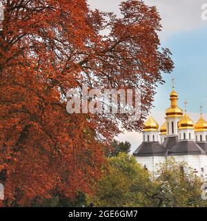 Schöne Kirche im Park. Goldene Kuppeln. Herbst Stockfoto