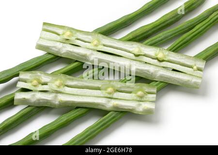 Frische rohe grüne ganze Moringa-Bohnen und Stecklinge mit Samen isoliert auf weißem Hintergrund Stockfoto