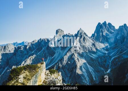 Luftaufnahme eines Mannes mit erhobenen Händen, der die Berggipfel von Cadini di Misurina, die italienischen Alpen, die Dolomiten, Italien, Europa genießt Stockfoto