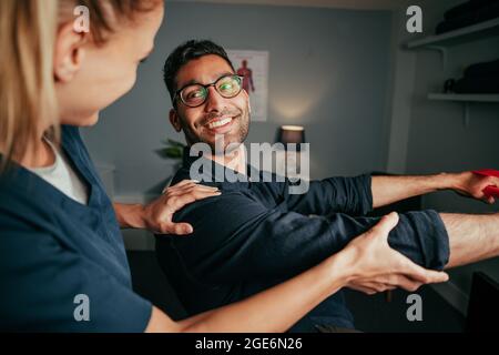 Gemischter männlicher Patient übt Rehabilitationsübungen Stockfoto