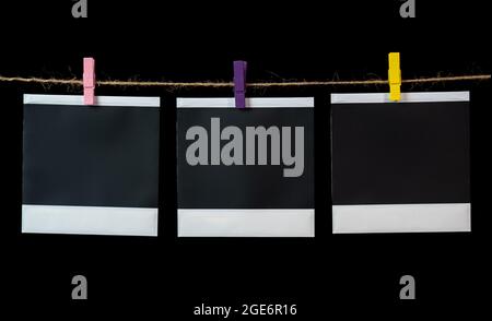 Leere quadratische Bilderrahmen, die an einer Wäscheleine hängen. Leere quadratische Bilderrahmen Stockfoto