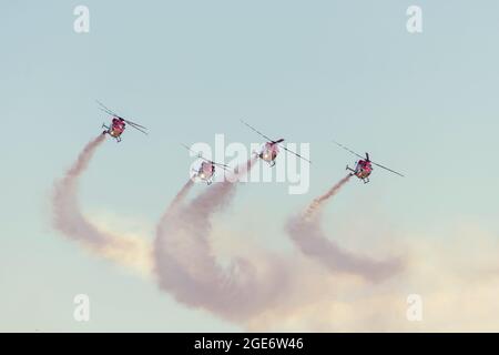 Luftkunstflug mit Hubschraubern, die am Himmel fliegen und eine Rauchspur hinterlassen Stockfoto