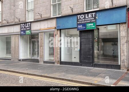 Zwei benachbarte leerstehende Geschäfte in der Union Street, Aberdeen. Ein „To Let“-Schild sagt, dass die beiden Räumlichkeiten kombiniert werden können. Stockfoto