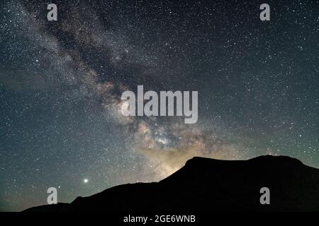 Die Berge ragen vor dem Hintergrund eines unglaublichen Sternenhimmels. Erstaunliche Nachtlandschaft mit Milchstraße. Nächtliche Astrofotografie Stockfoto