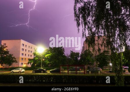 Ein Gewitter mit Blitzen zieht in der Nacht über eine Stadt Stockfoto
