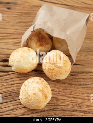 Typische brasilianische Käsebrühen in einem Papierbeutel über einem Holztisch. Stockfoto