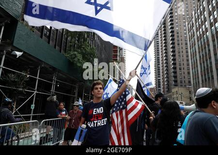 New York, Usa. August 2021. Israelische Gegendemonstler singen Slogans, während sie während einer freien palästinensischen Kundgebung in Midtown Manhattan Flaggen halten. Nach der Kundgebung vor dem israelischen Generalkonsulat marschierten die Demonstranten über einen Bereich mit mehreren Blöcken und endeten am Dag Hammarskjöld Plaza, wo sich die Gruppe zu einem Gruppenfoto versammelte. (Foto von John Lamparski/SOPA Images/Sipa USA) Quelle: SIPA USA/Alamy Live News Stockfoto