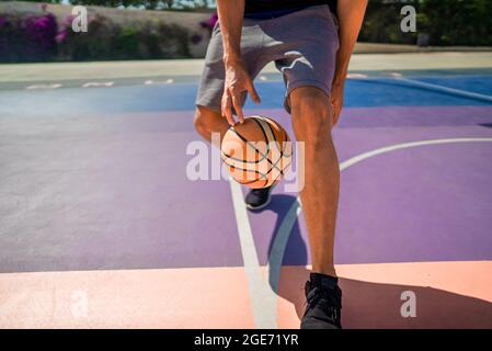 Beine eines professionellen Basketballspielers, der den Ball auf dem Basketballfeld Dribbeln kann. Das Spiel ist in vollem Gange Stockfoto