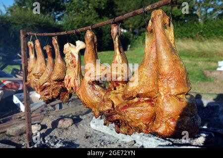 Lammkeule kochen über einem offenen Feuer in Suffolk, England Stockfoto