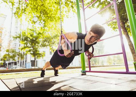 Ein junger, hübscher kaukasischer Mann in Sportkleidung, der am hellen Sommertag Sport macht. Stockfoto