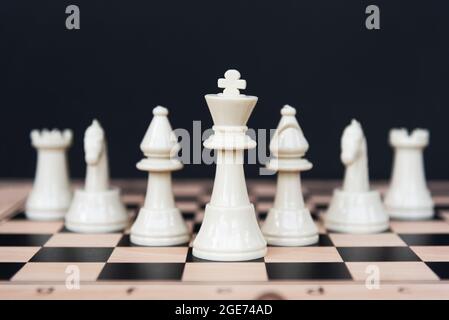 Leadership Concept - Weiße Schachfiguren auf schwarzem Hintergrund Stockfoto