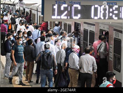 Mumbai, Indien. August 2021. Mehrere Menschen mit Gesichtsmasken steigen an einem Bahnhof in Mumbai in einen lokalen Zug ein. Nur diejenigen, die beide Impfdosen von Covid-19 erhalten haben, dürfen mit dem Zug in Mumbai reisen. (Foto von Ashish Vaishnav/SOPA Images/Sipa USA) Quelle: SIPA USA/Alamy Live News Stockfoto