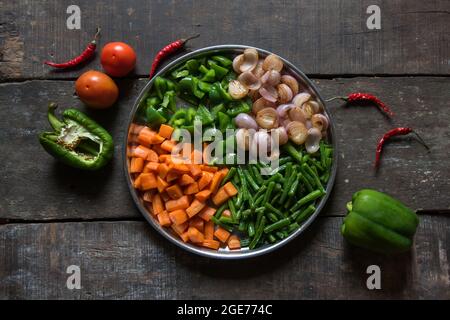 Frisch gehacktes rohes Gemüse Karotten, Bohnen, Zwiebeln und Paprika mit selektivem Fokus. Fertig zum Kochen. Stockfoto