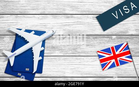 Reisepass in der Nähe der Flagge. Spielzeugflugzeug. Reise ins Land der Möglichkeiten. Neues Dokument in alter Tabelle. Stockfoto