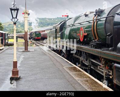 Dampfzug auf der Gloucestershire Warwickshire Railway, der von einem Bulleid-Motor der „Merchant Navy“-Klasse gezogen wird, fährt in Winchcombe einen weiteren Zug. Stockfoto