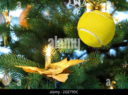 Tennis weihnachtskugel hängt auf dem Tannenzweig. Weihnachtsgrüße Stockfoto